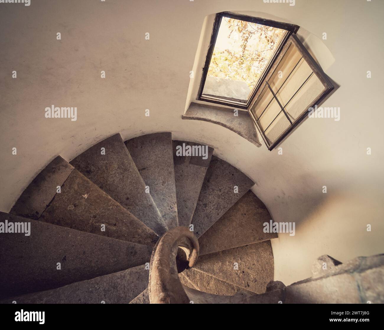 Alte Steintreppe in einem Turm - Blick von oben auf die Treppe. Perspektivische Sicht nach unten auf die runde Treppe im Uhrzeigersinn. Stockfoto