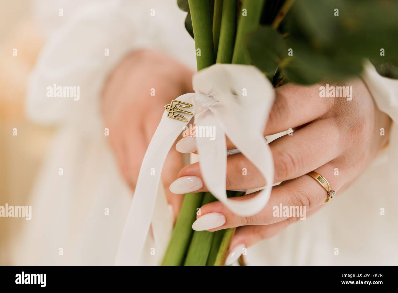 Die Braut hält einen Hochzeitsstrauß mit einem Bräutigam in den Händen Stockfoto