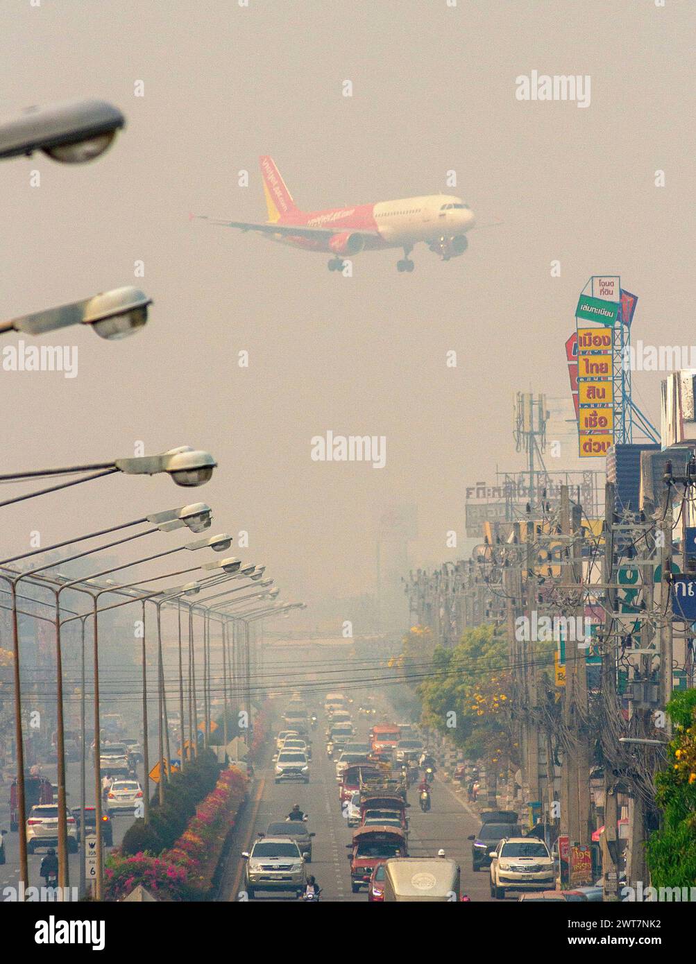 Chiang Mai, Thailand. März 2024. Ein VietjetAir-Flugzeug bereitet sich auf die Landung unter Smog aus hohen Konzentrationen von Feinstaub PM2,5 am internationalen Flughafen Chiang Mai vor. Am 16. März wurde die nördliche Stadt Chiang Mai in Thailand am 2. Tag in Folge auf den ersten Platz der zehn Städte mit der höchsten Luftverschmutzung gekürt. Quelle: SOPA Images Limited/Alamy Live News Stockfoto