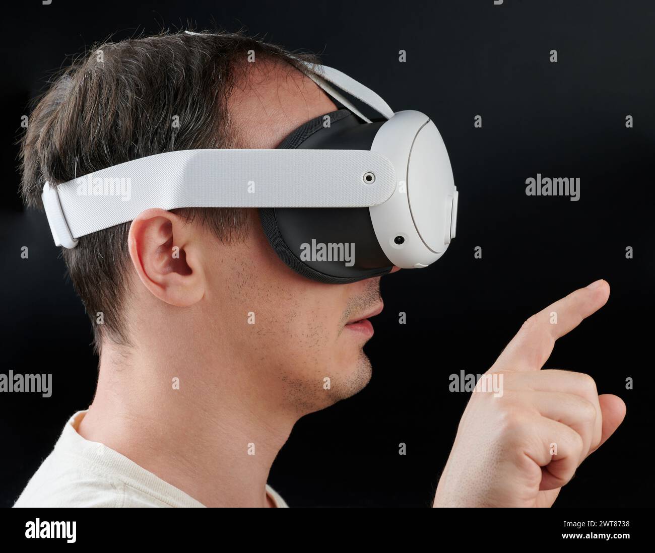 Mann im VR-Headset, Seitenansicht isoliert auf schwarzem Studiohintergrund Stockfoto