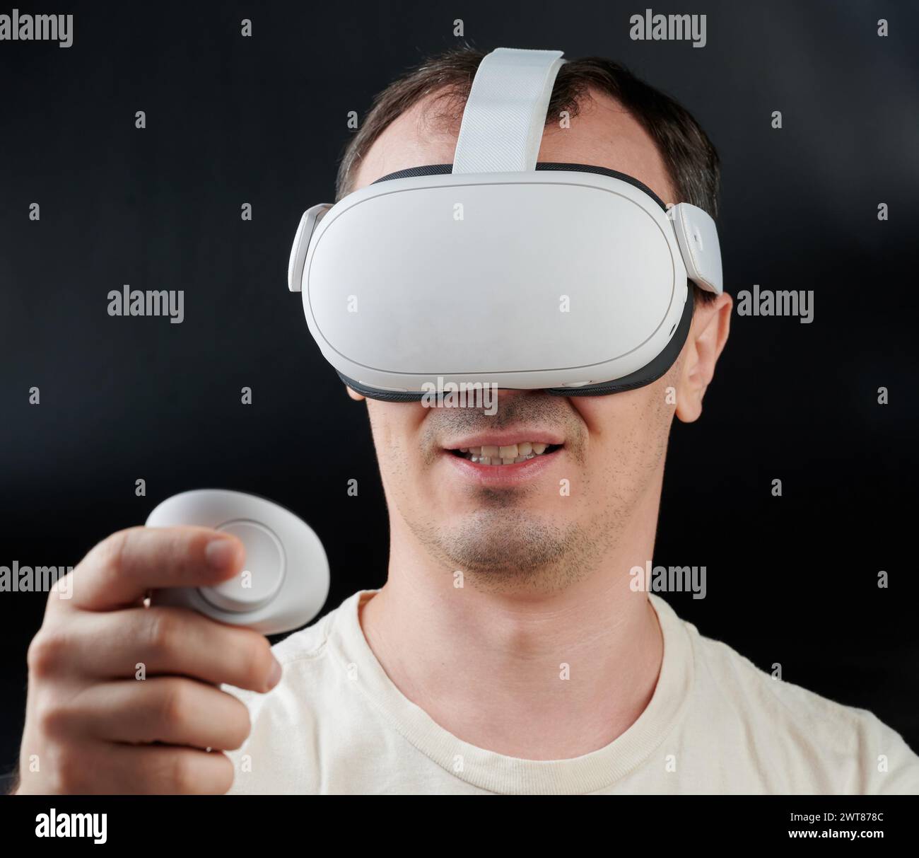 Lächelnder Mann in Virtual-Reality-Headset-Porträt isoliert auf schwarzem Studiohintergrund Stockfoto