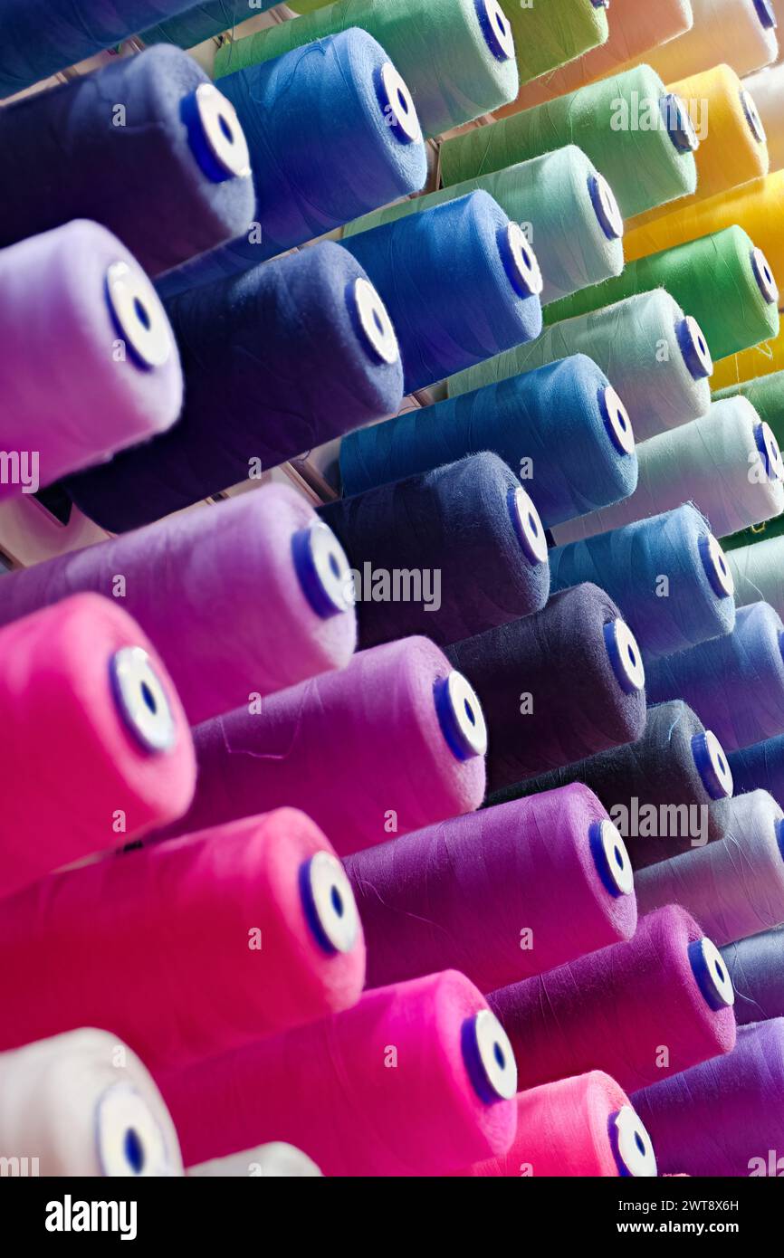 Verschiedene Spulen aus mehrfarbigen Baumwollfäden, abstrakter Hintergrund der Textilindustrie Stockfoto