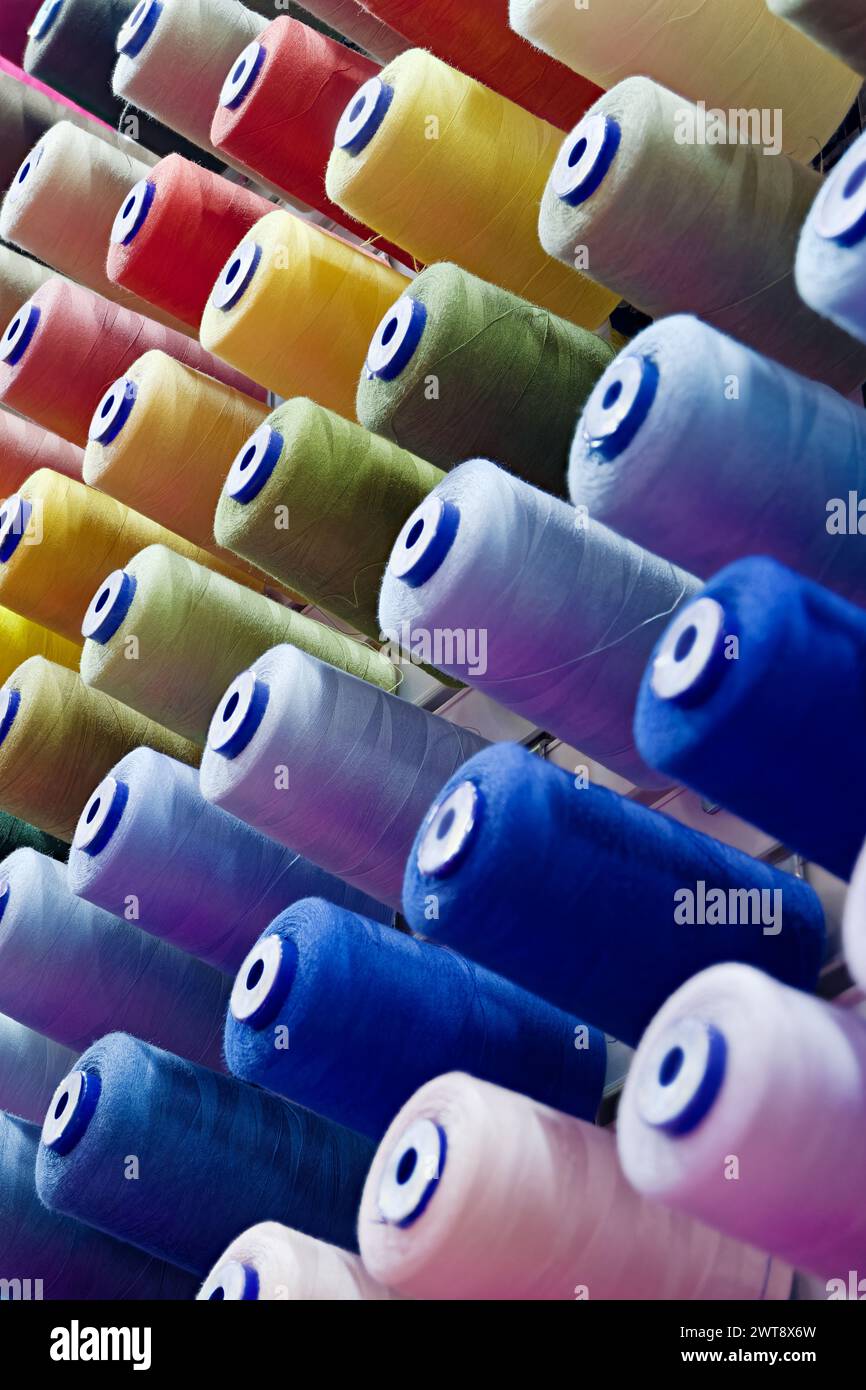 Verschiedene Spulen aus mehrfarbigen Baumwollfäden, abstrakter Hintergrund der Textilindustrie Stockfoto