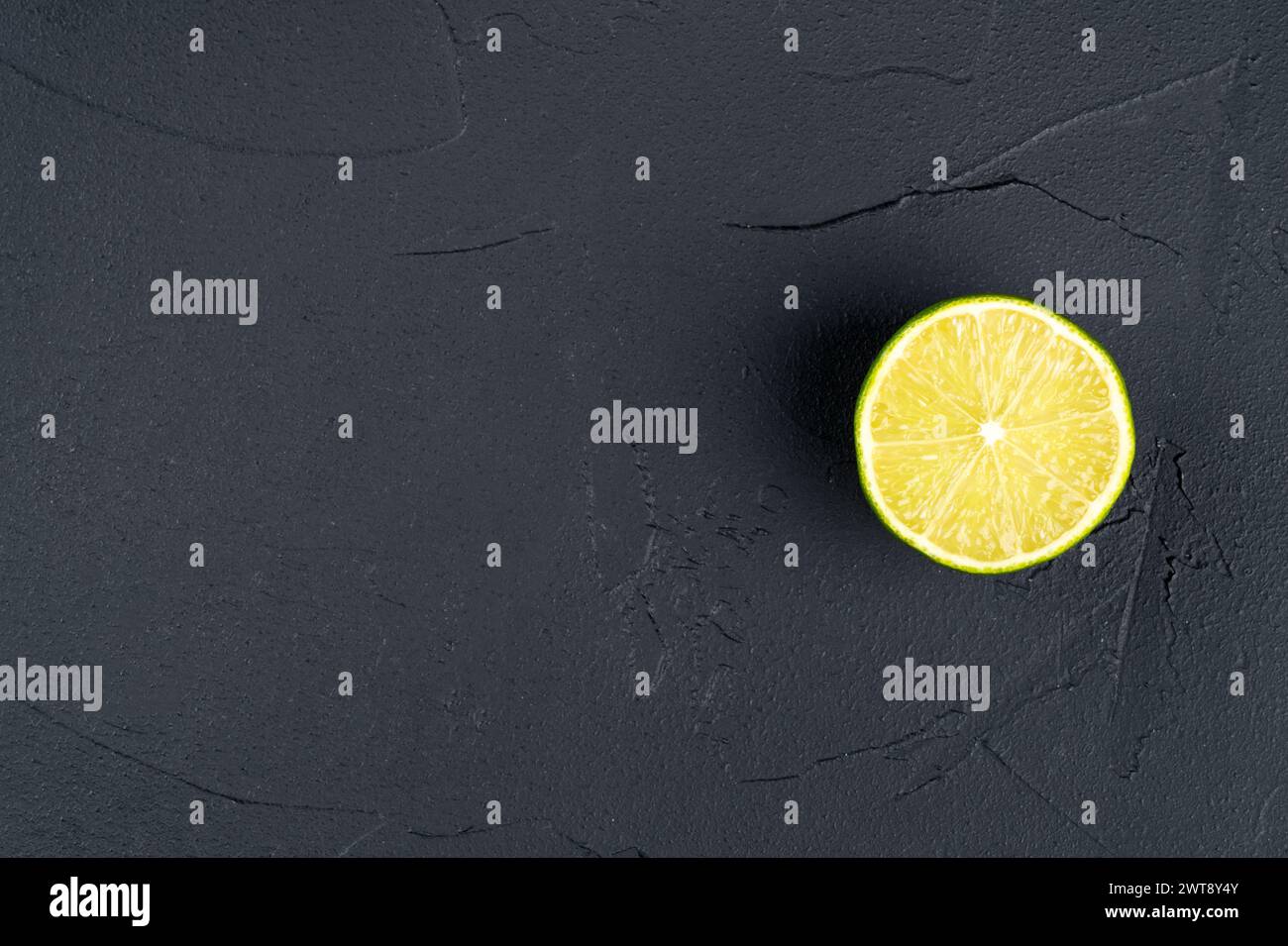 Saftige Hälfte Limettenfrucht auf dunklem Hintergrund, Kopierraum Stockfoto