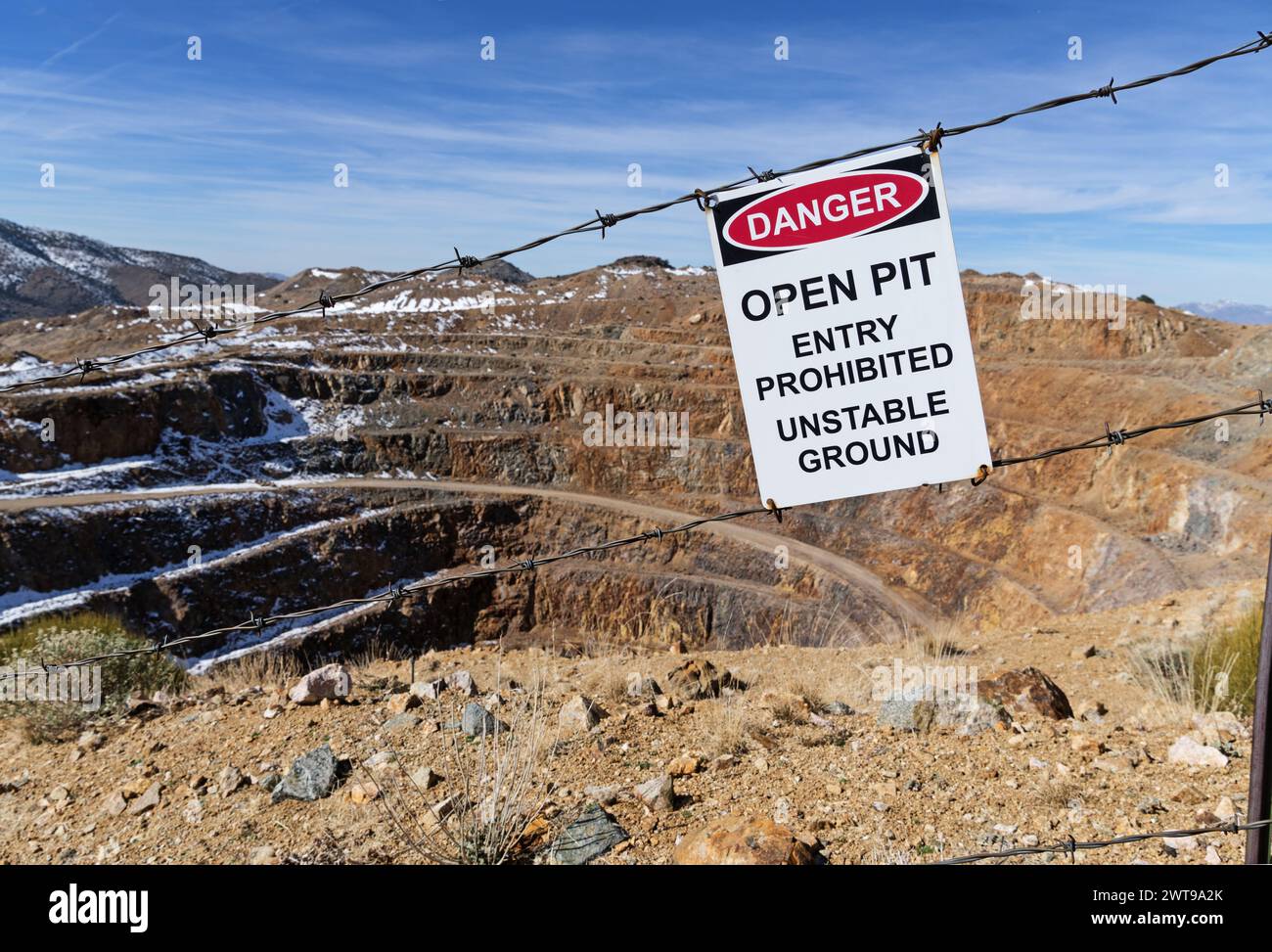 Der Eintritt in die offene Grube ist verboten, das Schild für instabilen Boden am Stacheldrahtzaun über der Goldmine Colosseum Open Pit in der Mojave-Wüste zu untersagen Stockfoto