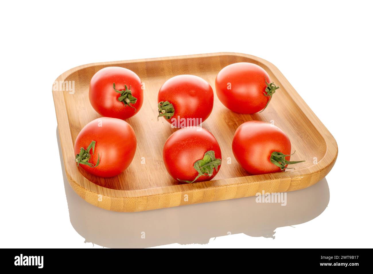 Mehrere reife Kirschtomaten auf einer Bambusplatte, Makro, isoliert auf weißem Hintergrund. Stockfoto