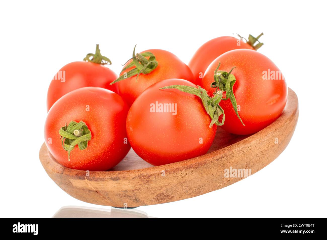 Mehrere reife Kirschtomaten mit einem Holzteller, Makro, isoliert auf weißem Hintergrund. Stockfoto