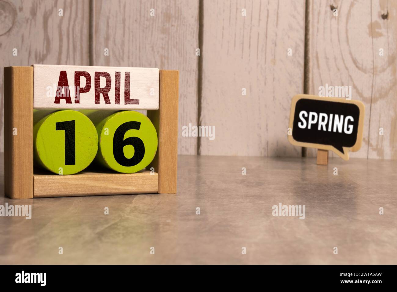 April 16. Holzwürfel mit Datum vom 16. April auf altblauem Holzhintergrund Stockfoto