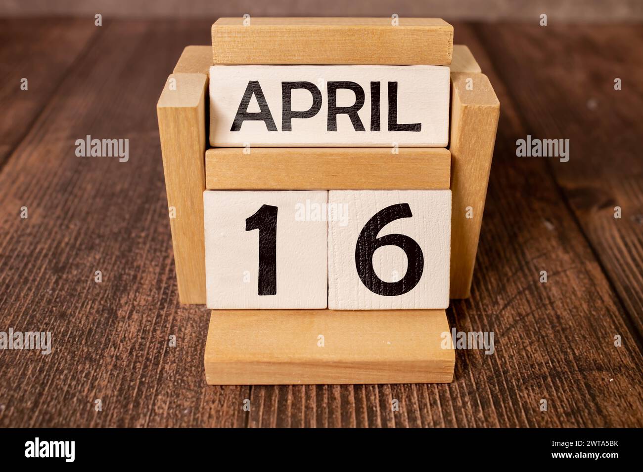 April 16. Holzwürfel mit Datum vom 16. April auf altblauem Holzhintergrund Stockfoto