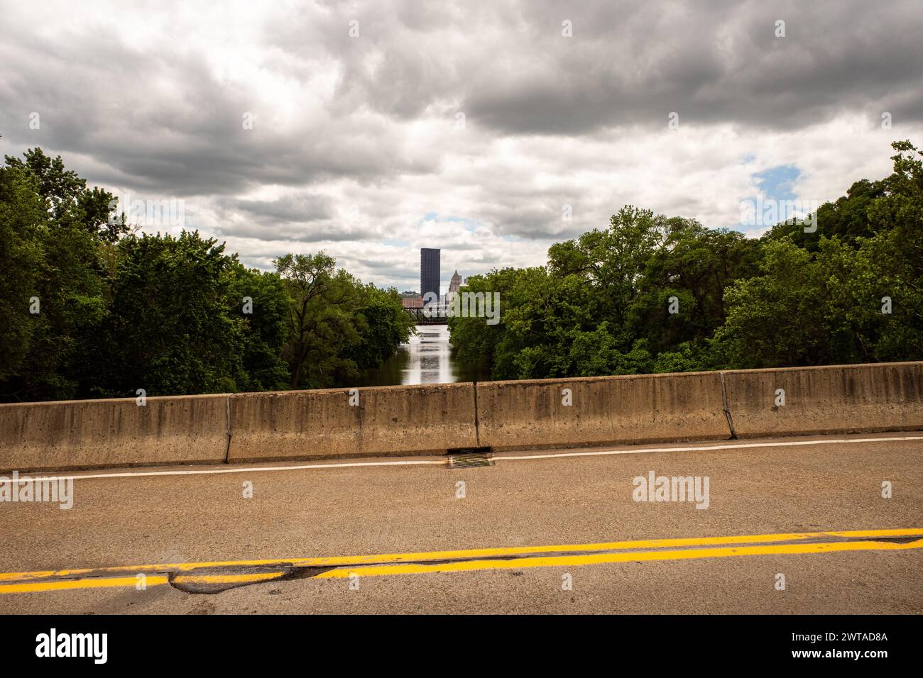 Von der 31st Street aus können Sie den UPMC Tower, der sich gegen die Skyline von Pittsburgh erhebt, mit leuchtenden gelben Straßenmarkierungen, die den Pfad entlang Herrs Island entlang ziehen, bestaunen Stockfoto