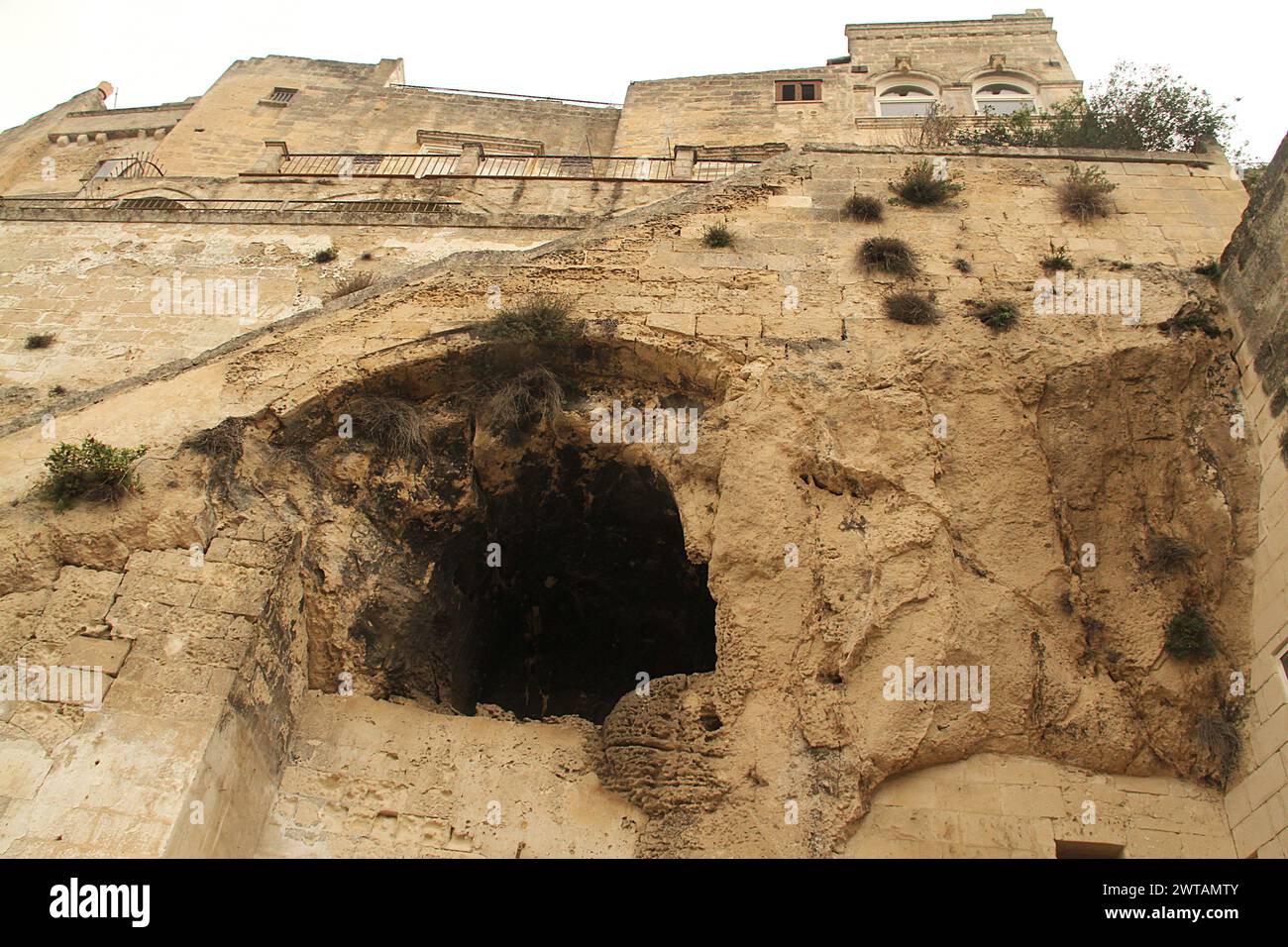 Matera, Italien. Gebäude im alten Sassi di Matera, mit einer Höhlenwohnung, die an der Klippe gegraben wurde. Stockfoto