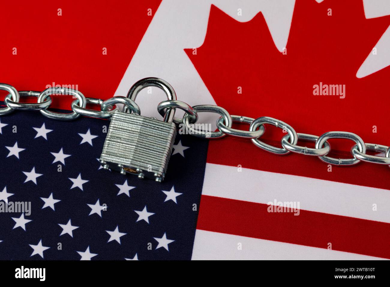 US-amerikanische und kanadische Flaggen mit Kette und Schloss. Grenzsicherheit, Einwanderungsreform und Krisenkonzept für illegale Migranten. Stockfoto