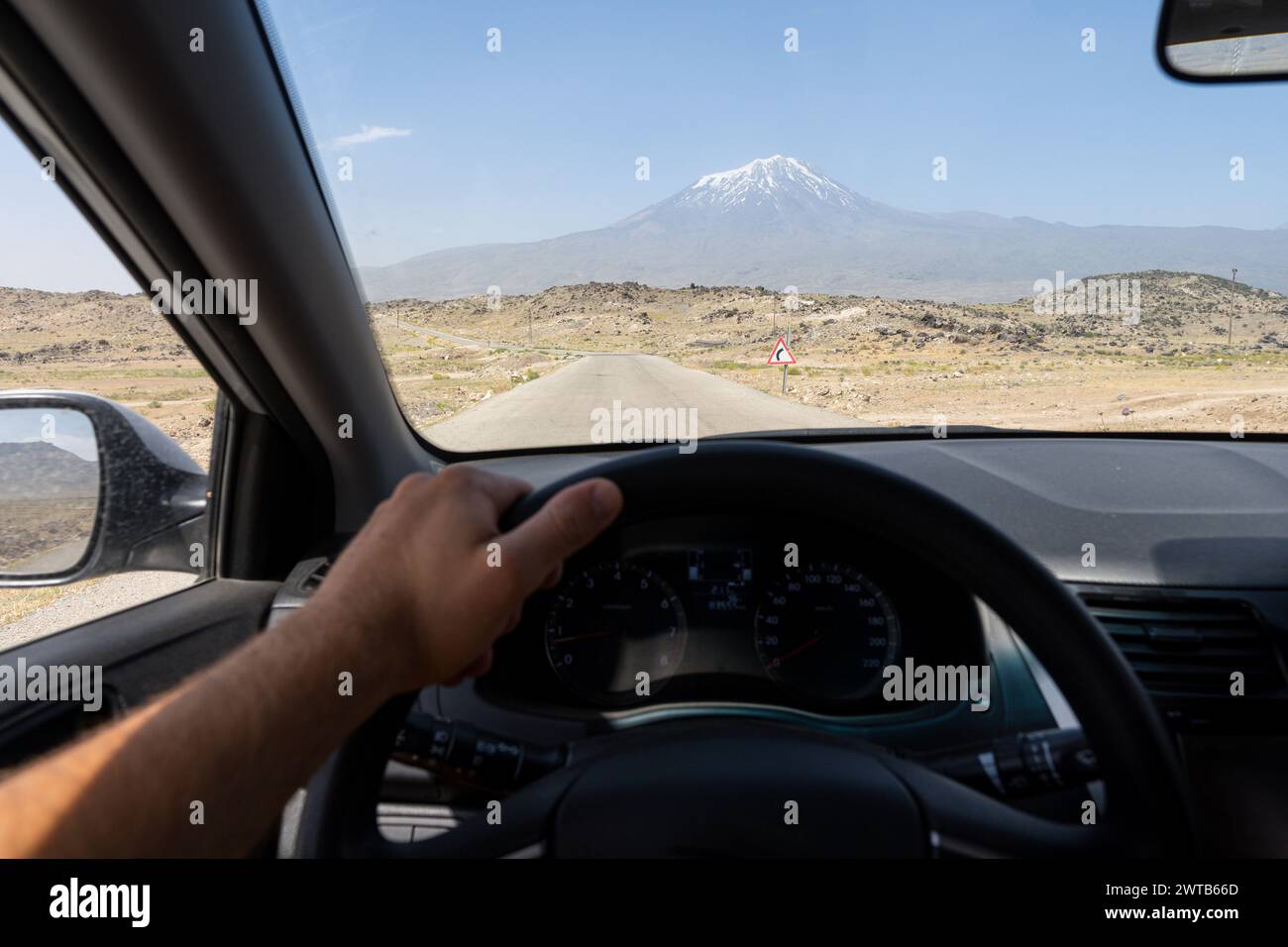 Blick auf den Ararat Berg durch die Windschutzscheibe des Autos. Blick auf den Fahrersitz über die Wüstenstraße in Südostanatolien in der Türkei Stockfoto