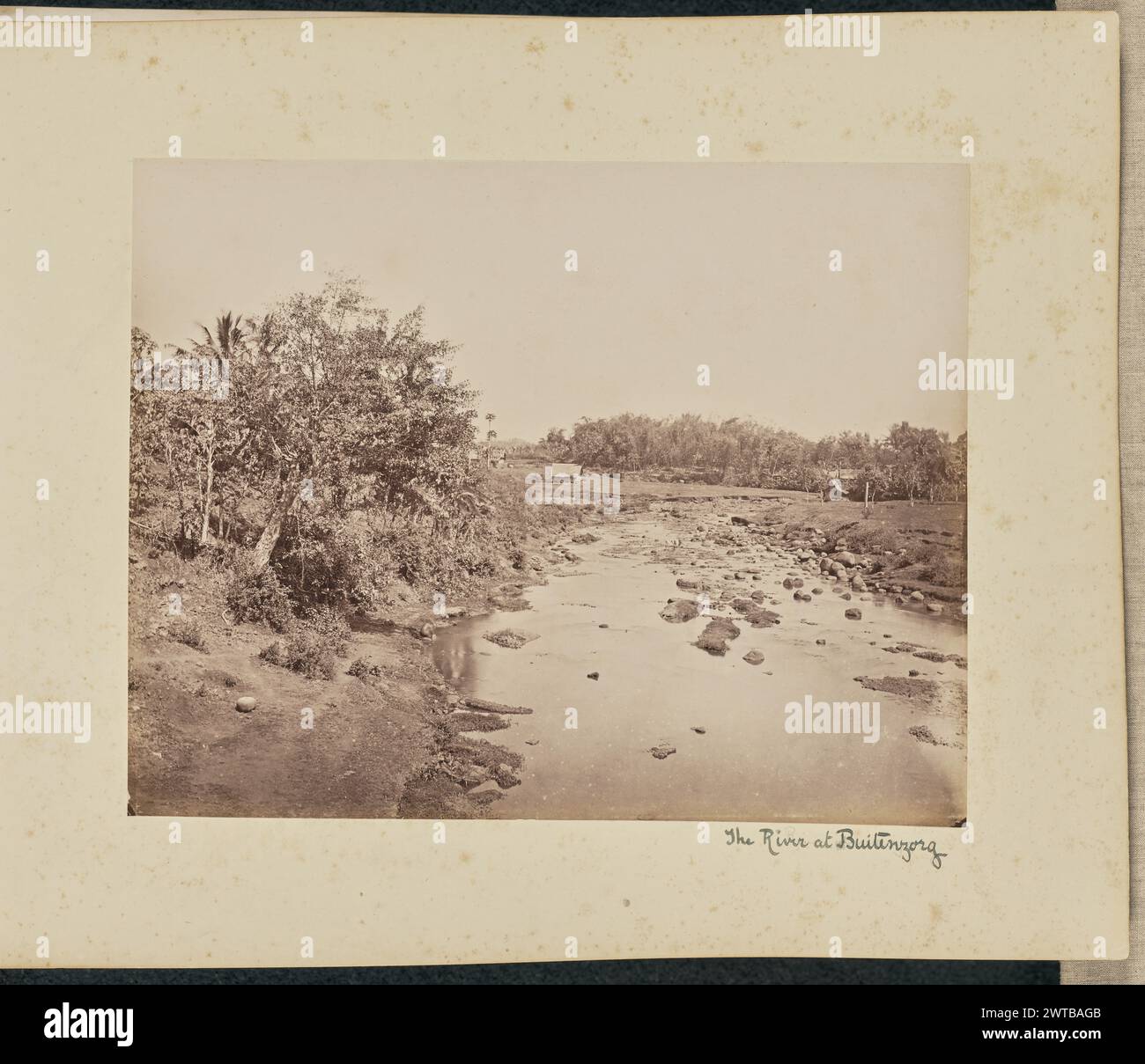 Der Fluss bei Buitenzorg. Woodbury & Page, Fotograf (britisch, aktiv 1857–1908) ca. 1870–1890er Jahre Blick auf einen felsigen Bach. Dieser Blick blickt auf ein paar kleine Hütten in der Ferne. (Recto, Mount) rechts unten in schwarzer Tinte: "Der Fluss bei Buitenzorg"; Stockfoto