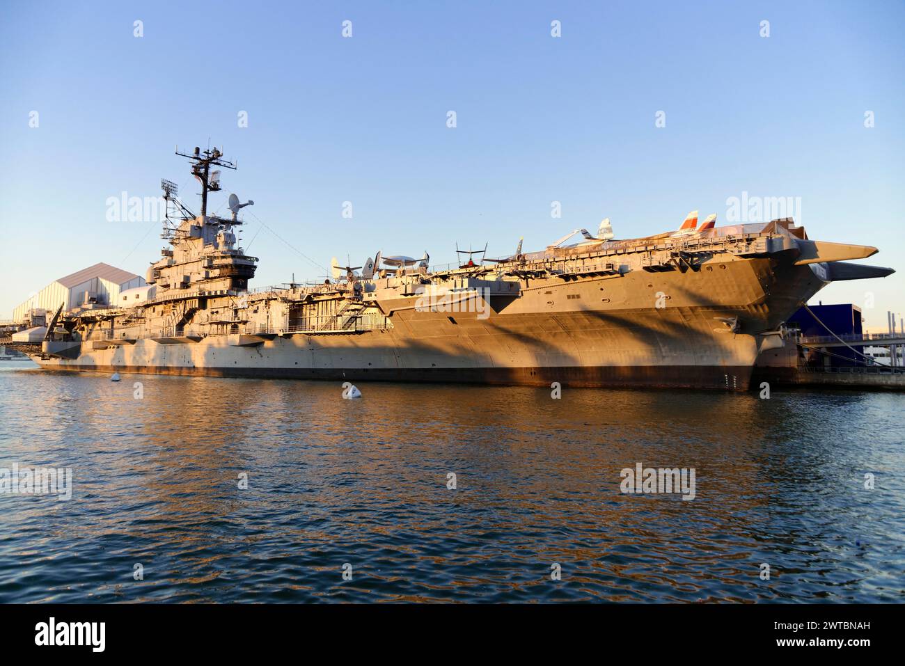 Die USS Intrepid, ein Flugzeugträger, der im Licht der Abenddämmerung als maritimes Museum am East River in Manhattan, Brooklyn, New York City dient Stockfoto