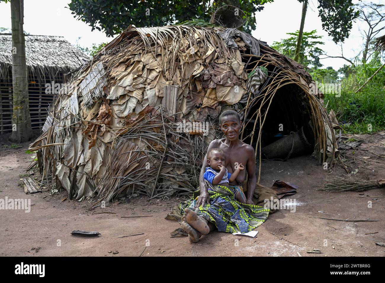 Zwergfrau der Baka oder BaAka mit ihrem Kind vor ihrer Hütte, Bayanga, Präfektur Sangha-Mbaere, Zentralafrikanische Republik Stockfoto