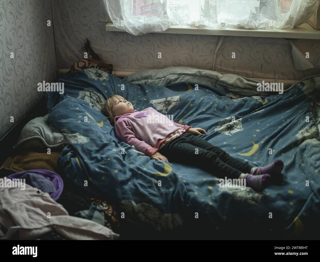 Angelina, 9 Jahre alt, auf ihrem Bett. Das Dorf Borschchiwka stand unter russischer Besatzung. Sie hat Angststörungen. Angelina und ihre Großmutter Stockfoto