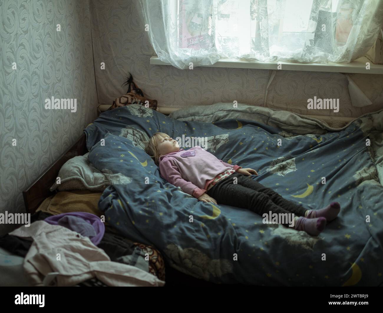 Angelina, 9 Jahre alt, auf ihrem Bett. Das Dorf Borschchiwka stand unter russischer Besatzung. Sie hat Angststörungen. Angelina und ihre Großmutter Stockfoto