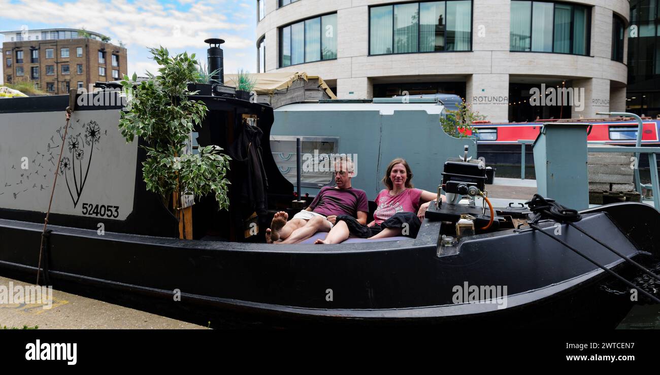 London - 06 03 2022: Das Paar ruht auf seinem Hausboot auf dem Regent’s Canal nahe dem Battlebridge Basin Stockfoto