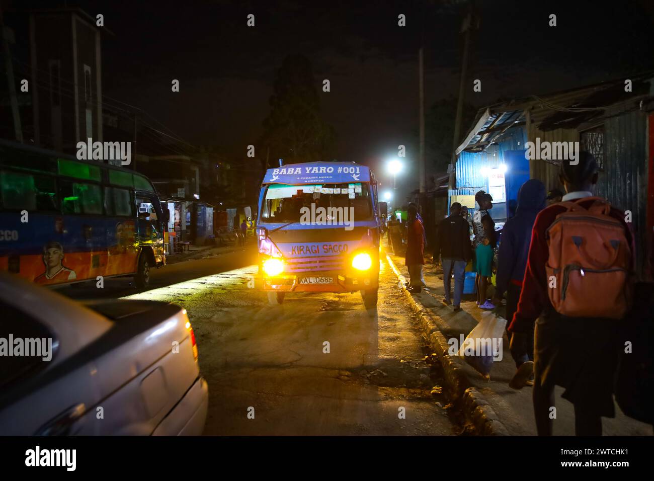 Autofahrer setzen Pendler ab, die von ihren verschiedenen Arbeitsorten ankommen. Kibera, der größte Slum in Nairobi und Afrika, beherbergt mehr als eine Mühle Stockfoto