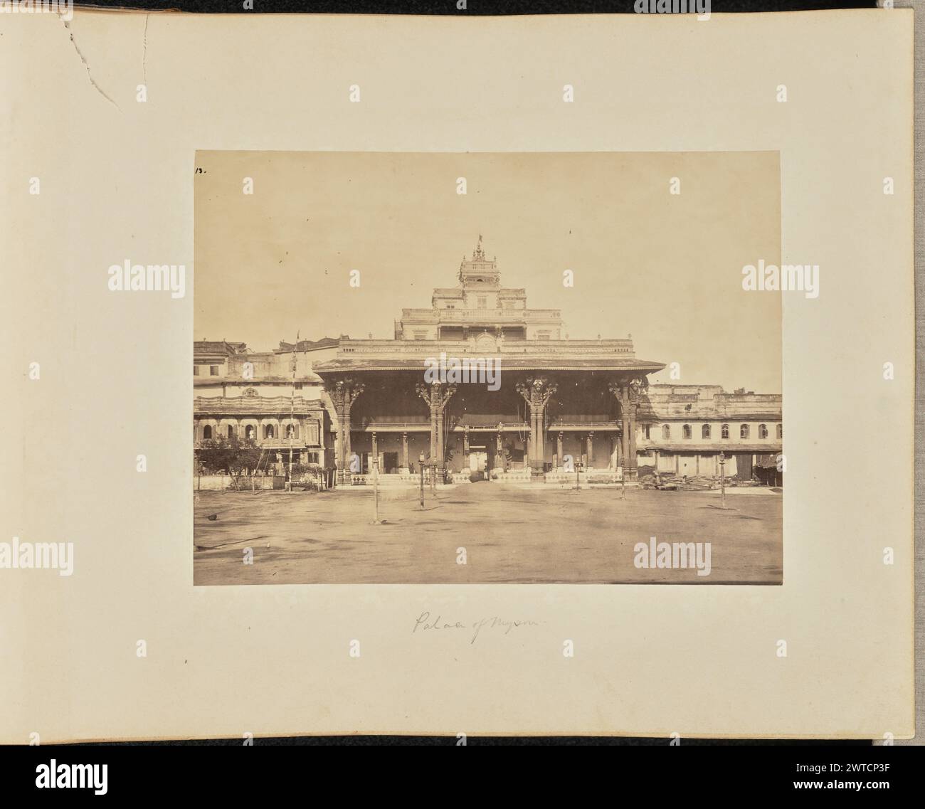 Palast von Mysore. Unbekannt, Fotograf ca. 1866–1870 Außenansicht des Alten Mysore-Palastes mit seinem Portikus und den abgestuften oberen Ebenen. Ein Mann steht am Eingang. (Recto, bedruckt) oben links, in schwarzer Tinte: '13.'; (Recto, Mount) unten in der Mitte, in Bleistift: 'Palace of Mysore'; (Verso, Mount) unten links, in Bleistift: 'A48.52'; Stockfoto