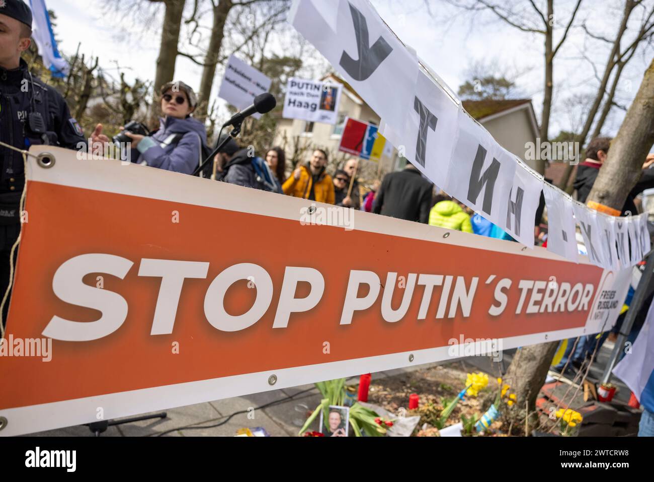 Bonn, Deutschland. März 2024. Demonstranten stehen gegenüber dem russischen Generalkonsulat und protestieren gegen Präsident Putin. Ein Banner mit der Inschrift „Stop Putins Terror“ ist an Bäumen angebracht. Die Russen wählen ihren Präsidenten. Quelle: Thomas Banneyer/dpa/Alamy Live News Stockfoto