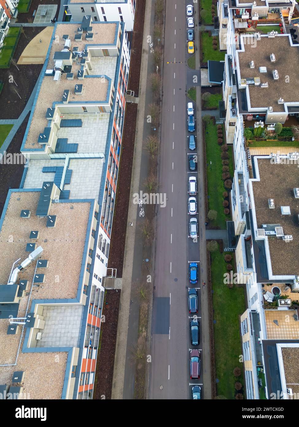 Eine obere, vertikale Ansicht einer modernen Straße in einem Apartmentkomplex mit Fahrradwegen und Straßen und Parkplätzen für PKW, sind städtisch Stockfoto