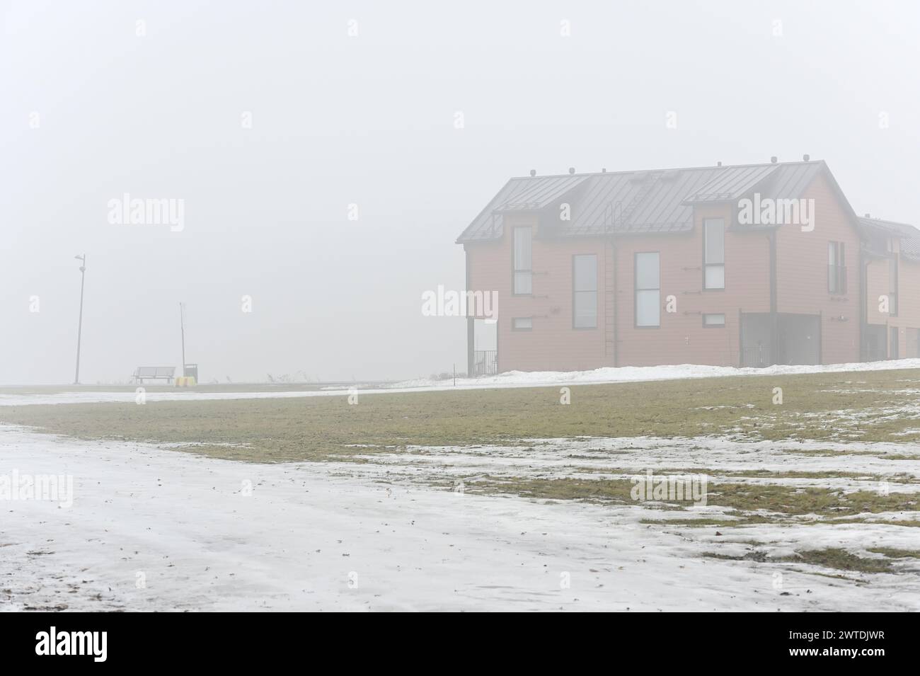 Typisches Wohngebäude und Rasen mit schmelzendem Schnee im Frühjahr in Finnland Stockfoto