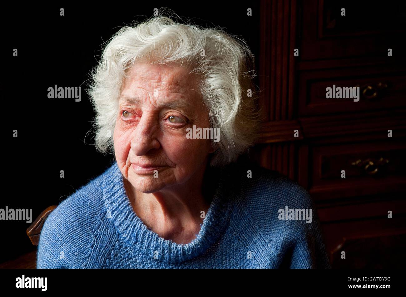 Porträt einer alten Frau zu Hause, die nach oben blickt. Stockfoto
