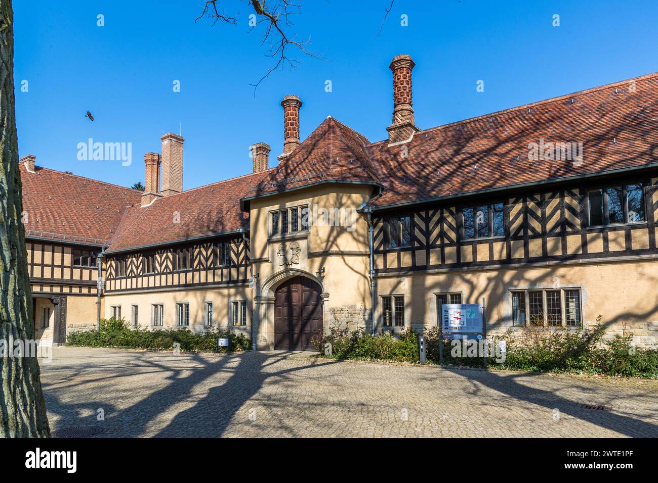 Schloss Cecilienhof ist ein Gebäudeensemble, das zwischen 1913 und 1917 im englischen Tudorstil nach Plänen des Architekten Paul Schultze-Naumburg errichtet wurde. Es befindet sich im nördlichen Teil des Neuen Gartens in Potsdam und ist das letzte Schloss der Hohenzollern. Sie wurde unter Kaiser Wilhelm II. Für seinen Sohn Kronprinz Wilhelm und seine Frau Cecilie erbaut. Schloss Cecilienhof war vom 17. Juli bis 2. August 1945 Schauplatz der Konferenz der Alliierten nach dem Zweiten Weltkrieg. Ökonomieweg, Potsdam, Brandenburg, Brandenburg, Deutschland Stockfoto