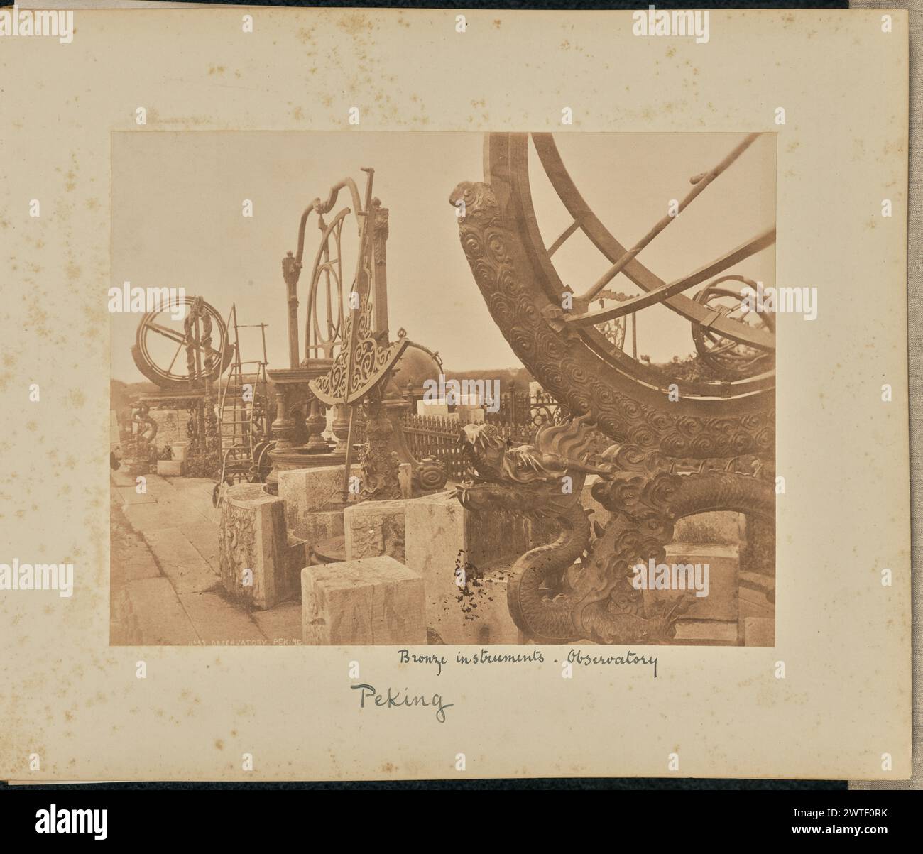 Beobachtungsstelle. Peking. Thomas Child, Fotograf (Britisch, 1841–1898) 1870–1880 Ansicht einer Reihe von astronomischen Instrumenten aus Bronze, Teil des Pekinger Alten Observatoriums. Teile der Instrumente sind kunstvoll gestaltet, mit Drachen und anderen mythologischen Tieren. Eine Drachenschnitzerei ist im Vordergrund sichtbar. (Recto, Druck) unten links, im negativ eingeschrieben, in weiß: 'No ['o' in hochgestellt] 53 OBSERVATORIUM. PEKING.“; (Recto, Mount) untere Mitte, in schwarzer Tinte: „Bronzeinstrumente. / Beobachtungsstelle / Peking"; Stockfoto