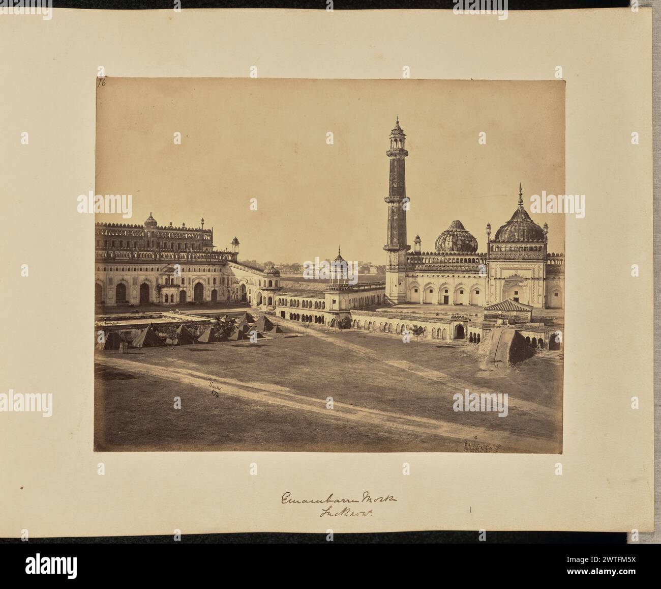 Emambarra Mosk. sic Lucknow. John Edward Saché, Fotograf (preußisch oder britisch, geb. Preußen, 1824–1882) 1864–1868 Ansicht der Bara Imambara und des Asafi Masjid. Die Bara Imambara, oder die große Imambara, ist im linken Bereich des Bildes zu sehen, ein Gemeinderaum islamischer Architektur mit einer Reihe von gewellten Bögen an der Fassade. Vor der Fassade des Gebäudes befindet sich ein plattformähnliches Gebäude, in dem einige Personen zu sehen sind, sowie eine Reihe von Kanonenkugelstapeln. Die Asafi Masjid, eine große Moschee mit zwei sichtbaren Kuppeln und einem Minarett, ist im rechten Bildbereich zu sehen. ( Stockfoto