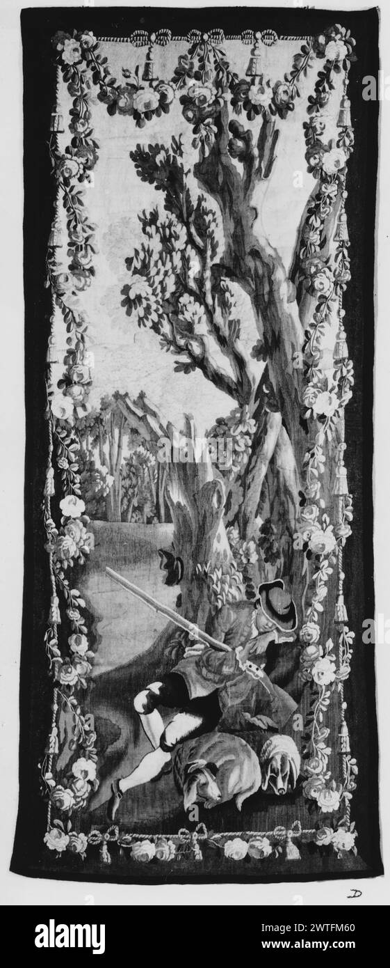 Hunter ruht sich bei seinen Hunden aus. Unbekannt ca. 1770-1790 Gobelin Materialien/Techniken: Unbekannt Kultur: Französisches Weberzentrum: Aubusson Besitz Geschichte: Französisch & Co. In einer Landschaft mit Bäumen, einem Jäger, der mit gefalteten Händen gegen einen Baum döstet und sein Vogelstück hält, neben zwei Hunden (BRD) in einem mit Seilen und hängenden, mit Bogen gebundenen Quasten und Blumenfestoon, ist der Designer nicht identifiziert. French & Co. Stock Sheet fehlt im Archiv, 33007-d Verwandte Werke: Panels im Satz: GCPA 0240484-0240486, 0184443-0184445 Stockfoto