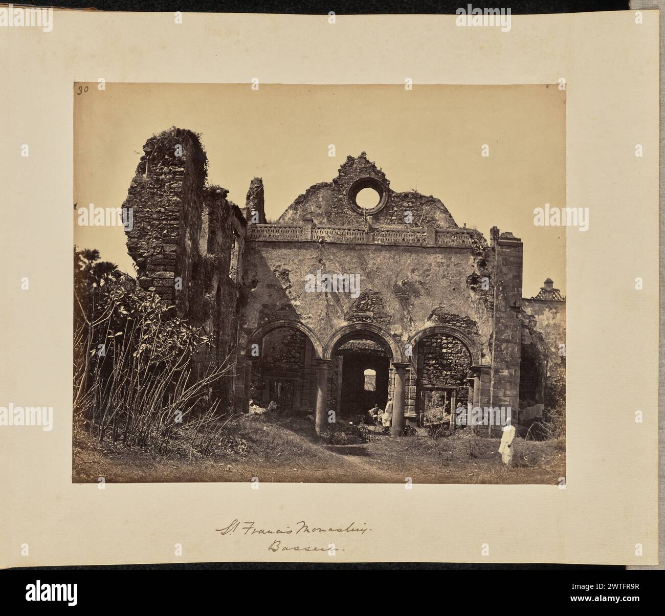 Franziskus-Kloster. Bassein. John Edward Saché, Fotograf (preußisch oder britisch, geb. Preußen, 1824–1882) um 1869 Blick auf die Ruinen eines Steingebäudes mit drei Bögen. Vier Männer stehen und sitzen an verschiedenen Orten im und um das Gebäude herum. (Recto, bedruckt) oben links, in brauner Tinte: '30'; unten rechts, im negativ beschriftet: '431'; (Recto, Mount) unten in der Mitte, in brauner Tinte: 'St. Franziskus-Kloster. / Bassein."; (Verso, Montage) unten links, in Bleistift: 'A48.51 (Saché)'; unten rechts, in Bleistift: '43'; Stockfoto