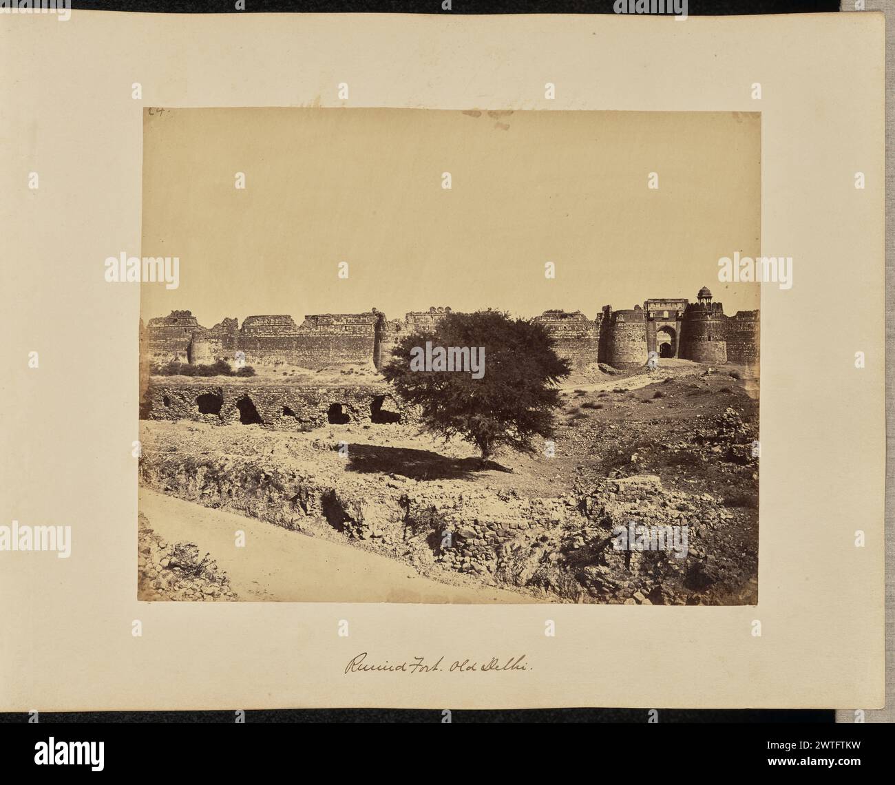 Ruine Des Forts. Alt-Delhi. John Edward Saché, Fotograf (preußisch oder britisch, geb. Preußen, 1824–1882) 1864–1868 Blick auf die Festungsanlage Purana Qila oder das Alte Fort aus der Ferne. Das Fort ist in einem Zustand von Ruinen mit Trümmern, die im Vordergrund verstreut sind. Die Bara Darwaza, manchmal auch Westtor genannt, ist im mittleren rechten Bereich des Bildes mit einem Chattri oder einem dekorativen Kuppelpavillon auf einem seiner Tortürme zu sehen. (Recto, Druck) links oben in brauner Tinte: '24.'; unten in der Mitte, im negativ beschriftet: '117'; (Recto, Mount) unten in der Mitte, in brauner Tinte: 'Ruined Fort. Stockfoto Ruine Des Forts. Alt-Delhi. John Edward Saché, Fotograf (preußisch oder britisch, geb. Preußen, 1824–1882) 1864–1868 Blick auf die Festungsanlage Purana Qila oder das Alte Fort aus der Ferne. Das Fort ist in einem Zustand von Ruinen mit Trümmern, die im Vordergrund verstreut sind. Die Bara Darwaza, manchmal auch Westtor genannt, ist im mittleren rechten Bereich des Bildes mit einem Chattri oder einem dekorativen Kuppelpavillon auf einem seiner Tortürme zu sehen. (Recto, Druck) links oben in brauner Tinte: '24.'; unten in der Mitte, im negativ beschriftet: '117'; (Recto, Mount) unten in der Mitte, in brauner Tinte: 'Ruined Fort. Stockfoto