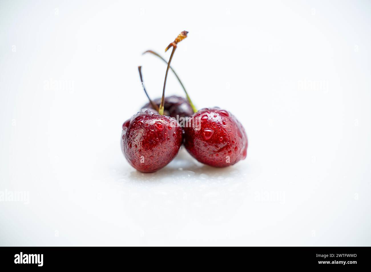 Kirschen auf weißem Hintergrund. Nahaufnahme, selektiver Fokus. Stockfoto