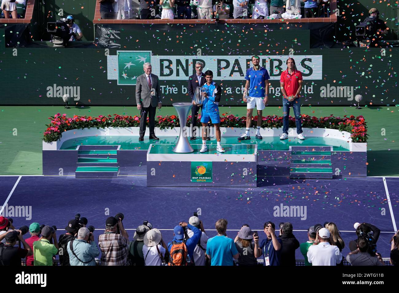 Carlos Alcaraz, of Spain, holds the trophy after defeating Daniil Medvedev, of Russia, second from right on stage, in the final match at the BNP Paribas Open tennis tournament, Sunday, March 17, 2024, in Indian Wells, Calif. (AP Photo/Mark J. Terrill) Stockfoto