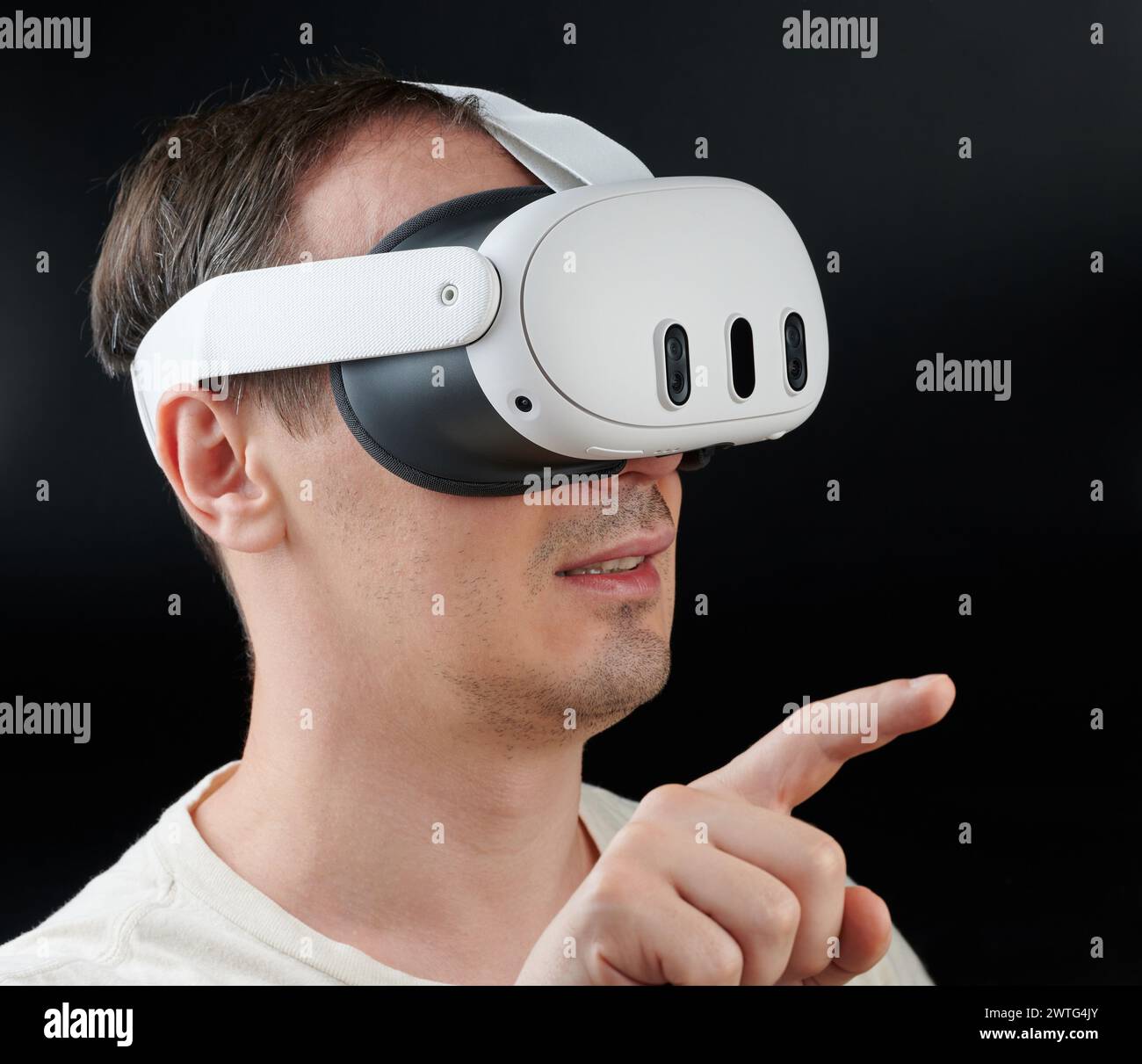 New York, USA - 15. März 2024: Man in Virtual Reality mit Meta Quest 3 auf schwarzem Studiohintergrund Stockfoto