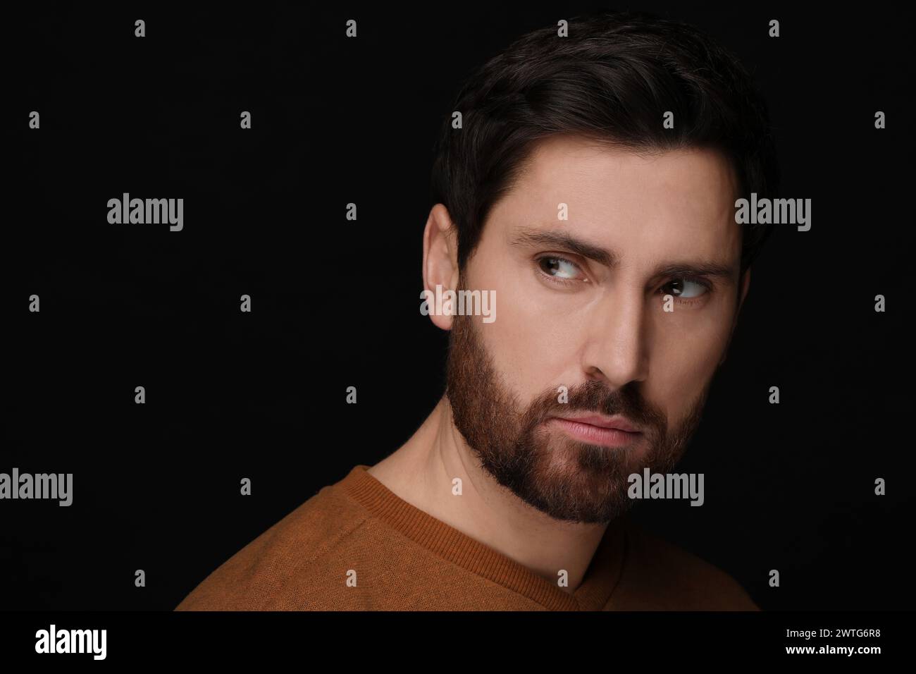 Böses Auge. Mann mit gruseligen Augen auf schwarzem Hintergrund, Nahaufnahme und Platz für Text Stockfoto