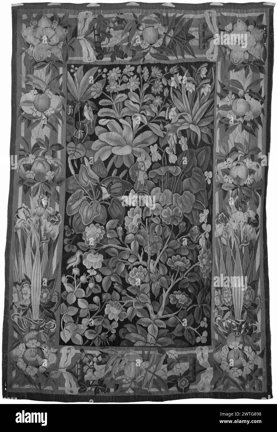 Großes Grünblatt mit Vögeln und Iris/Granatapfelrand. Unbekannt ca. 1545-1565 Gobelin Abmessungen: H 8' x B 5'5' Gobelin Materialien/Techniken: Unbekannt Kultur: Flämisches Weberzentrum: Unbekannt Besitz Geschichte: Französisch & Co. Gekauft von Ernest Joresco, erhalten 15.1962; verkauft an V. & C. [Vigo & Charles] Sternberg 7.10.1962. 7 Vögel bewohnen Grün mit verzweigtem Laub und Blumen (BRD) Iris & kurze Granatapfelgirlanden & Blumen gebunden mit Bändern French & Co. Stock Sheet im Archiv, E-493 Göbel, Wandteppiche I:2 (1923), Abb. 442 Verwandte Werke: Kompositorisch und stilistisch ähnlich Stockfoto