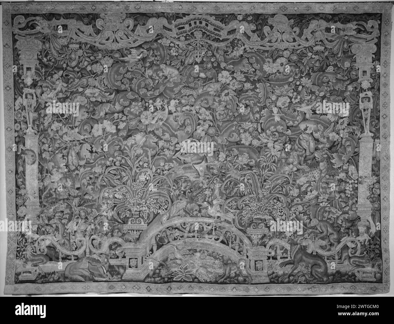 Grobblättriges Proszenum-Grün mit Ententeich. Unbekannt ca. 1550-1600 Gobelin Abmessungen: H 11 x B 15' Gobelin Materialien/Techniken: Unbekannt Kultur: Flämisches Weberzentrum: Unbekannt Besitz Geschichte: Französisch & Co. Gekauft von Henry Symons, fakturiert am 23.11.1927; verkauft an das Kunstgewerbemuseum 1961. Ausgeklügeltes Proszenum mit Vordergrundgeländer mit 2 Urnen auf Sockeln, & grotesken Seitensäulen, die das Gesims stützen; Enten im Teich, 2 Katzentiere, 1 mit Jungen, & Affen vor der Brüstung; hinter der Brüstung, Grün bestehend aus rollenden Akanthus-ähnlichen Blättern und blühenden Pflanzen Stockfoto