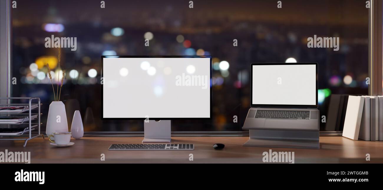 Ein modernes Büro in einem Wolkenkratzer bei Nacht mit Computer und Laptop mit weißem Bildschirm auf einem Schreibtisch vor dem Glasfenster mit Blick auf die Stadt. 3D-rendering Stockfoto