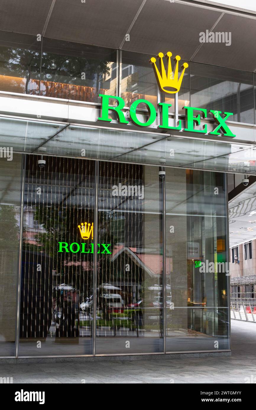 Rolex-Logo und Namensschild vor der Ladenfassade, die Besucher aus der Ferne oder in der Nähe sehen können, um eine Uhr zu kaufen. Singapur. Stockfoto