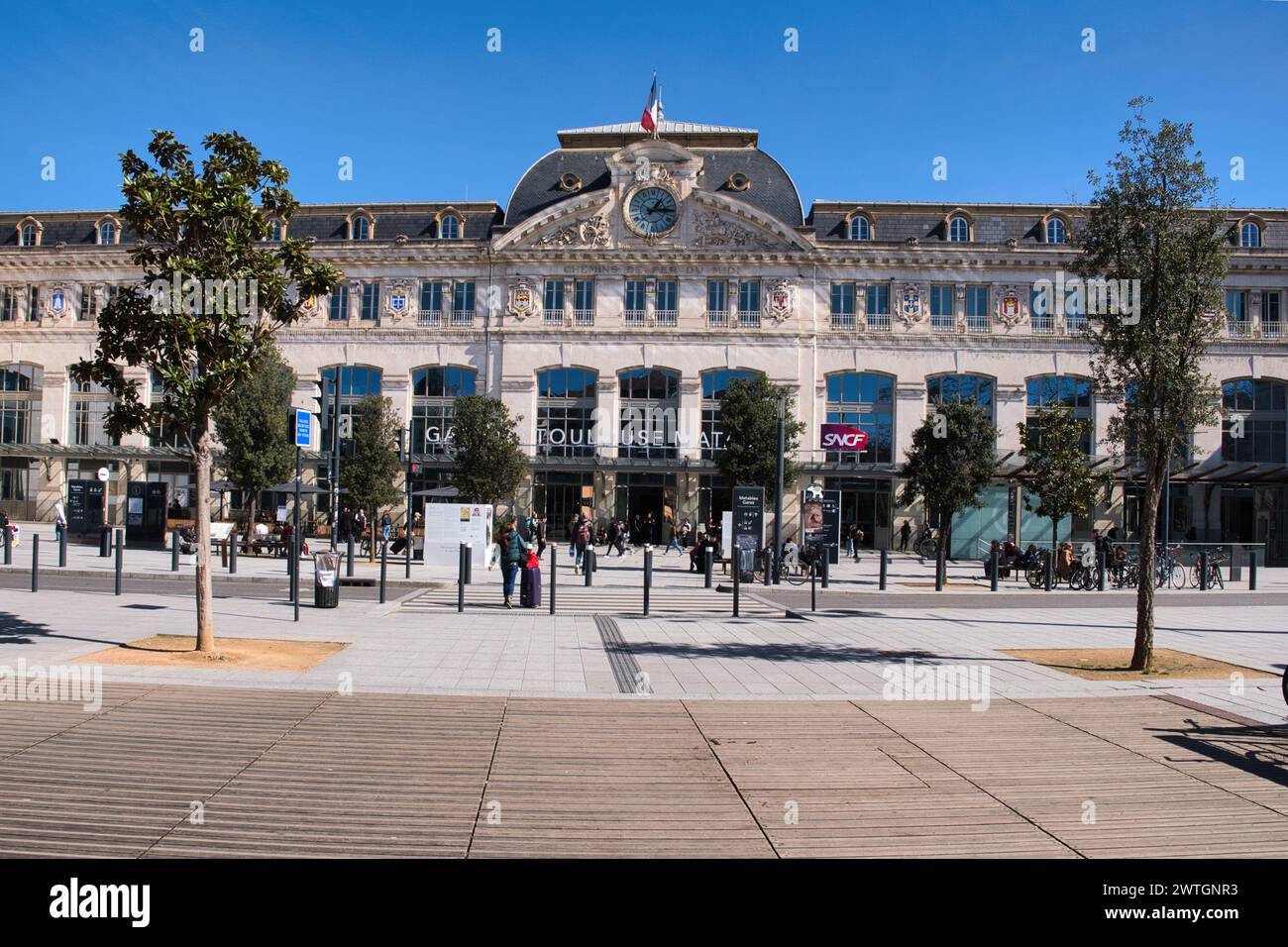 Toulouse Haute Garonne Frankreich 03.13.24 Bahnhof Matabiau. Zeitgebäude mit Uhr. Fußgängerzone. Mansarddach. Bäumen öffentlicher Bereich. D Stockfoto