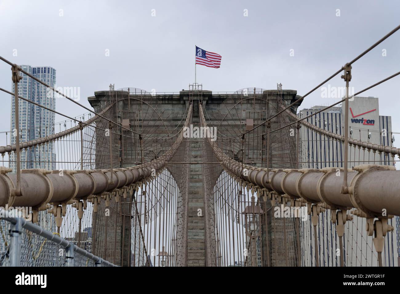 Brooklyn Bridge, zentraler Blick auf die Spitze einer großen Brücke mit einer schwenkenden amerikanischen Flagge, Manhattan, New York City, New York, USA, Nordamerika Stockfoto