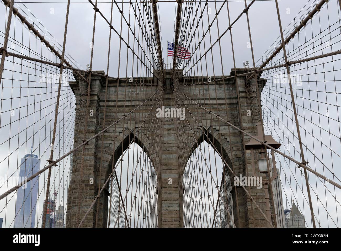 Brooklyn Bridge, Nahaufnahme eines Brückenturms mit schwenkender Flagge, umwickelt in Seile und Kabel, Manhattan, New York City, New York, USA, Nordamerika Stockfoto