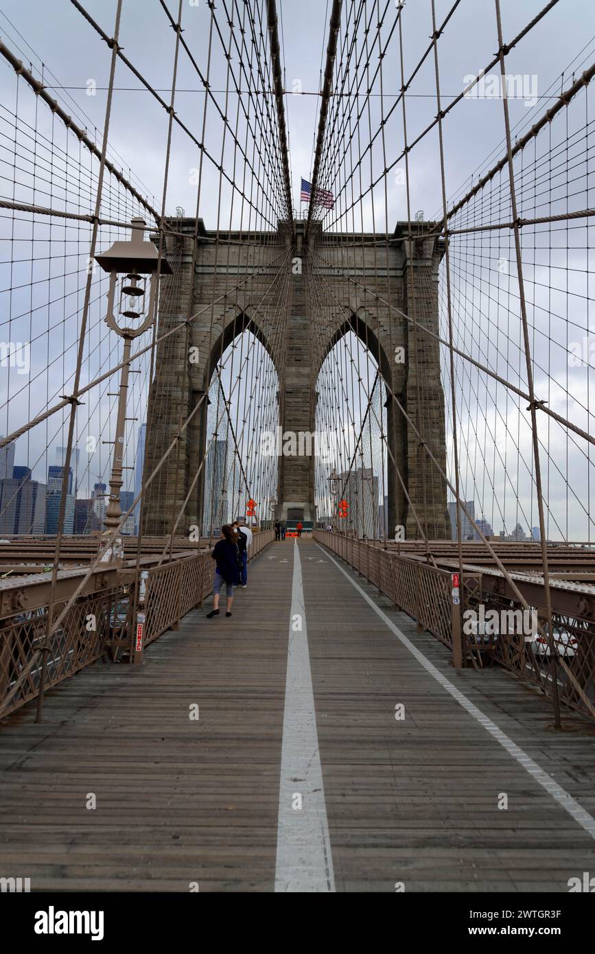 Menschen, die auf dem Bürgersteig der Brooklyn Bridge mit Seilen und Blick auf die Stadt laufen, Manhattan, New York City, New York, USA, Nordamerika Stockfoto