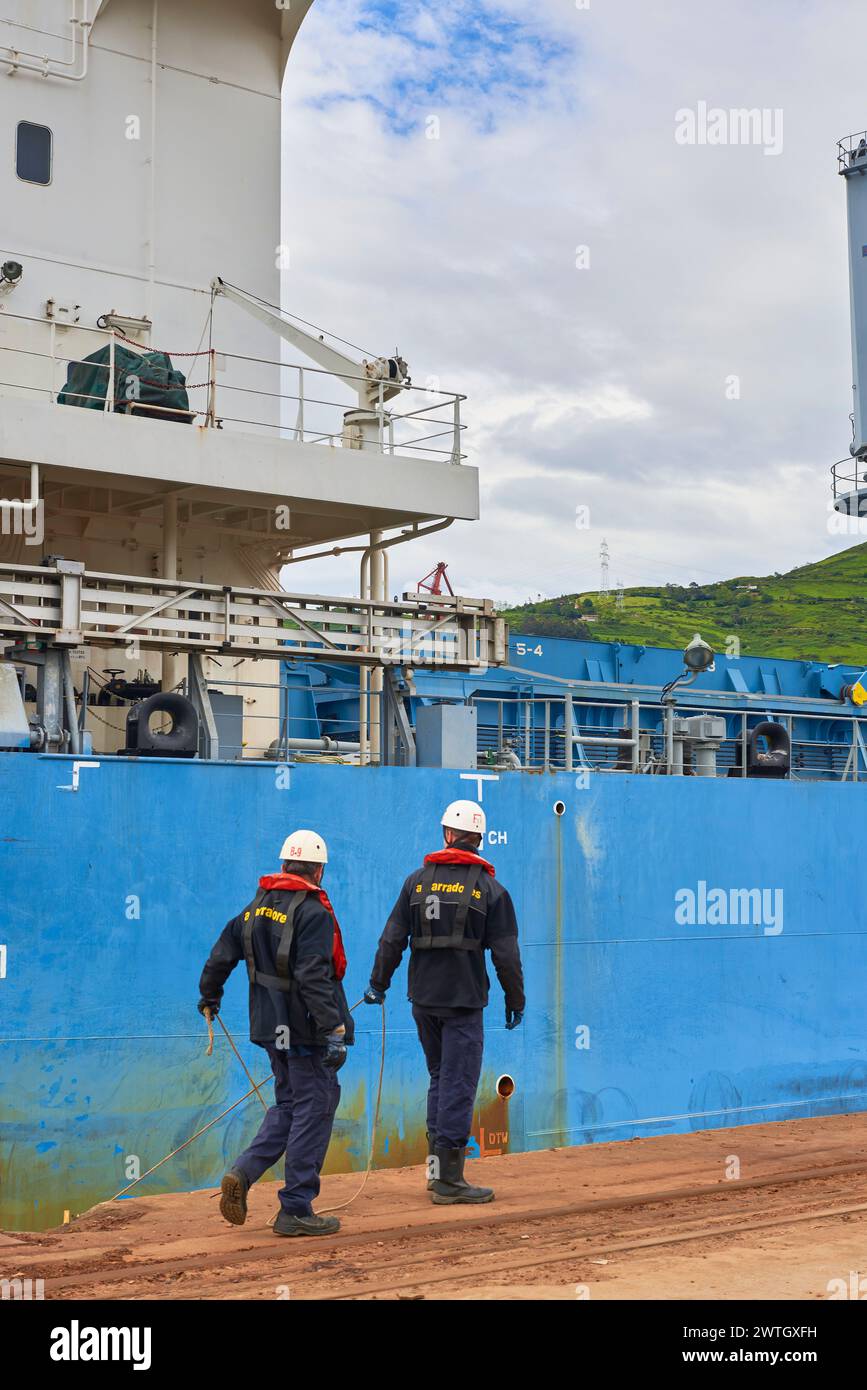Zwei Hafenarbeiter, die ein Frachtschiff im Hafen von Bilbao, Biskaya, Baskenland, Euskadi, Spanien, Europa Stockfoto