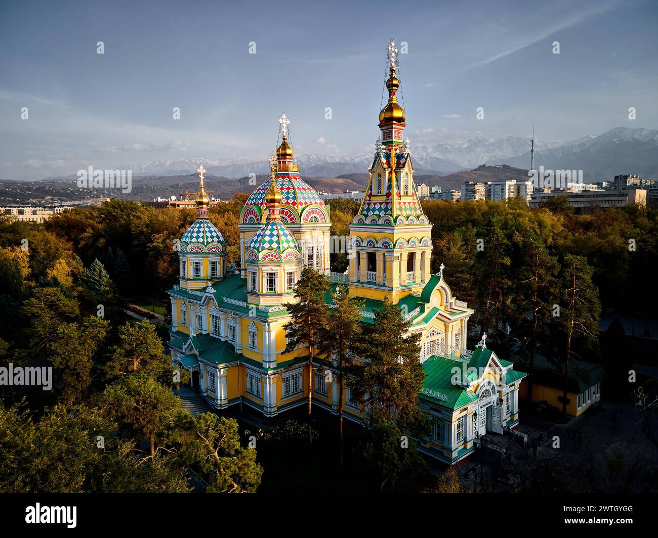 Luftdrohnen-Panorama der Ascension Cathedral Russisch-orthodoxe Kirche und Schneeberge im Hintergrund im Panfilov Park vor Sonnenuntergang Himmel in Almat Stockfoto