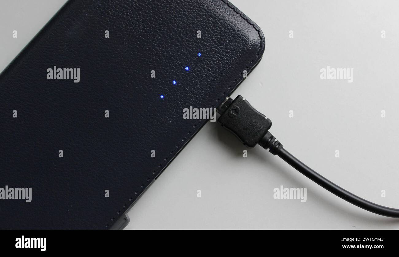 Blaue Dioden der Ladeskala zeigen die volle Ladung der Powerbank an, isoliert auf weiß Stockfoto
